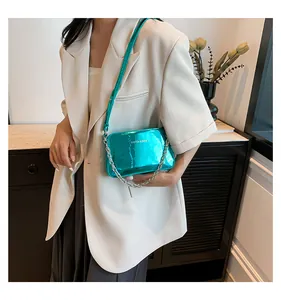 Close-up of metallic green crossbody bag with silver chain and white fashion text logo