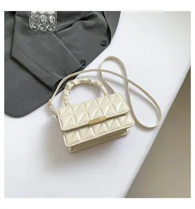 Vue détaillée de dessus du sac bandoulière en cuir verni crème avec matelassage triangle