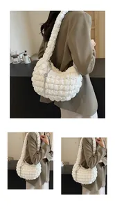 Detailed view of white quilted puffy cloud bag with a decorative metallic fringe chain