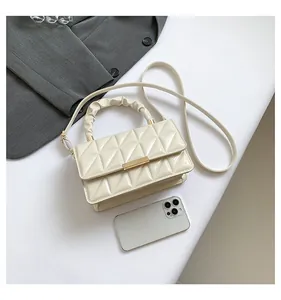 Détail du mini sac en cuir verni matelassé avec fermoir doré et poignée plissée