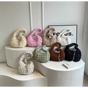 Detail view of quilted cloud bags in eight colors displayed on minimalist white stands