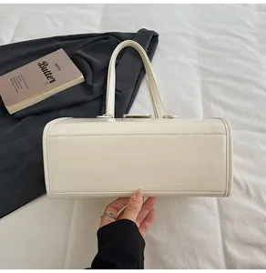 Detail of cream rectangle tote bag with textured faux leather and slim round handles