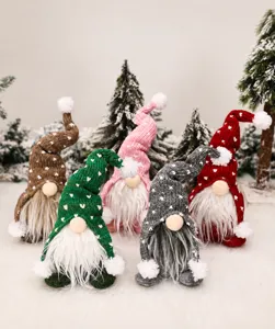 Gros plan de cinq gnomes de Noël tricotés avec motifs cœurs et pompons en peluche