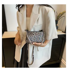 Detail of leopard print faux leather bag with silver chain handle and adjustable strap