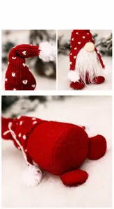 Détail d'un gnome de Noël rouge avec bonnet en tricot à cœurs et barbe blanche douce