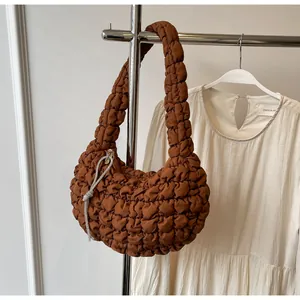 Detail view of caramel brown quilted bubble bag featuring silver rhinestone chain accent