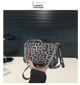 Detailed close-up of leopard print crossbody bag with silver chain and adjustable strap