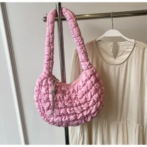 Close-up of pink quilted cloud bag with bubbly texture and sparkling silver tassel detail