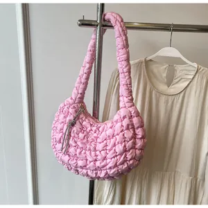 Detailed close-up of pink quilted bubble fabric shoulder bag with silver fringe charm