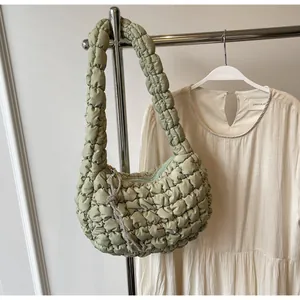 Detail of light green quilted bubble shoulder bag with a rhinestone knotted charm