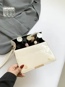 Sac bandoulière minimaliste en cuir verni matelassé beige avec finitions dorées