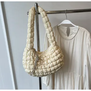 Detailed close-up of cream quilted cloud bag with textured bubble fabric and tassel charm