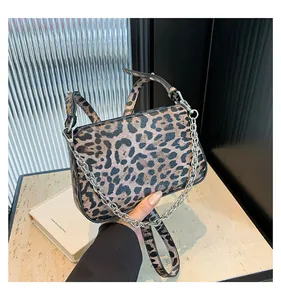 Detail view of leopard print crossbody bag with silver chain and adjustable leather strap