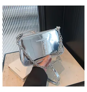 Detailed macro view of the silver mirror surface and chain strap of this chic shoulder bag