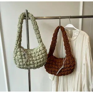 Close-up of light green and brown nylon bubble tote bags showing ruched cloud texture