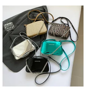 Flat lay of five fashion shoulder bags with metal chains in various textures and colors