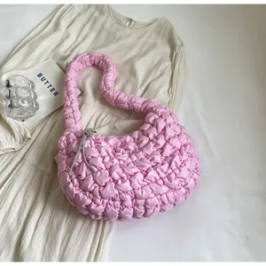 Macro shot of pink pleated cloud bag featuring silver rhinestone knot and soft texture