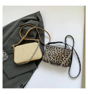 Detail of beige woven and leopard print shoulder bags with silver chain decorations