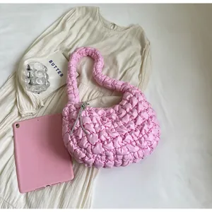 Detail of pink quilted cloud bag featuring a sparkling silver rhinestone knot ornament