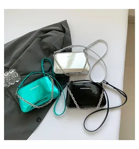 Detailed comparison of metallic green, silver, and black chain handbags with print