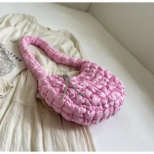 Macro detail of pink ruched cloud bag featuring a sparkling silver rhinestone bow charm
