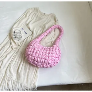 Detail of pink quilted cloud bag with 3D bubble texture and soft fabric on neutral background