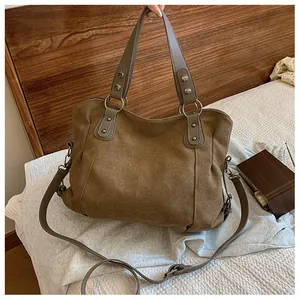 Détails du sac fourre-tout marron avec rivets métalliques et bandoulière réglable