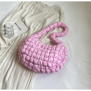 Detailed view of pink quilted cloud shoulder bag with pleated texture and soft nylon fabric