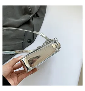 Close-up of metallic silver mirror surface handbag with decorative chain and strap