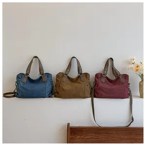 Trois sacs cabas en toile bleu, marron et bordeaux avec poignées et bandoulières