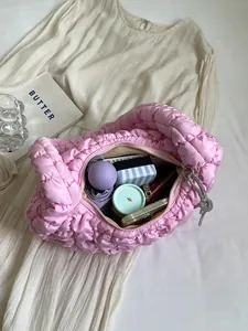 Pink quilted cloud shoulder bag with large capacity showing daily items on a dress