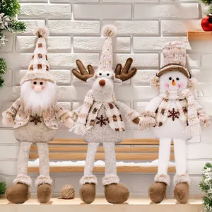 Three Christmas plush dolls with long legs sitting on a wooden bench with pine tree decor