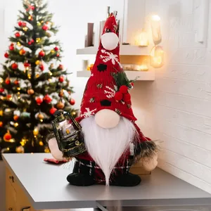Detail of Christmas gnome holding a glowing lantern with knitted snowflake hat decoration