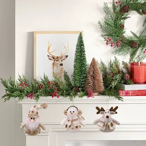 Three plush Christmas ornaments featuring Santa, snowman, and reindeer on a mantel