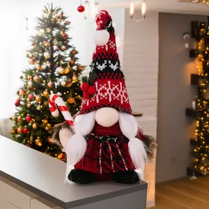 Detail of Christmas gnome plush with candy cane and warm holiday background bokeh