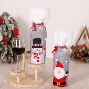 Dettaglio copribottiglie in feltro grigio con ricamo Babbo Natale e pelliccia sintetica bianca