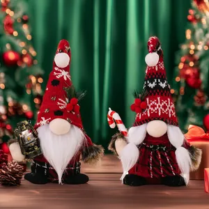 Detail of Christmas gnomes with lantern and candy cane on a festive wooden surface