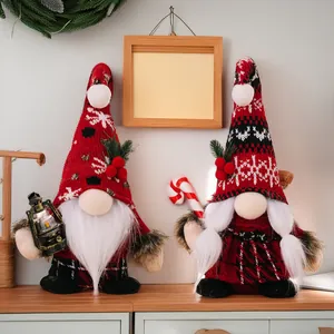 Close-up of Christmas gnomes with knit hats, handheld lantern and candy cane decor