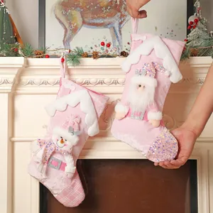 Pink Christmas stockings with Santa and Snowman figures on a festive fireplace mantel
