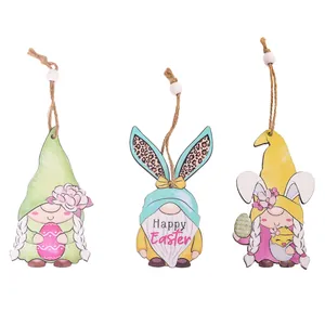 Trois gnomes de Pâques en bois coloré avec oreilles de lapin et motifs floraux