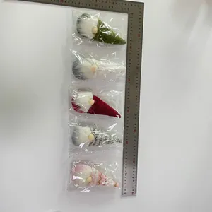 Dettaglio di cinque gnomi natalizi in maglia con barbe bianche e righello graduato