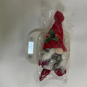 Gedetailleerd beeld van een kerstgnom pluche figuur die op een weegschaal ligt