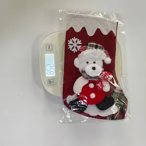 Detailed view of red burlap Christmas stocking with 3D teddy bear mascot on weight scale