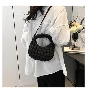 Vue lifestyle d'un sac bouffant matelassé noir avec poignée plissée et bandoulière