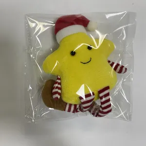 Detail of plush yellow star toy with Christmas hat in transparent packaging