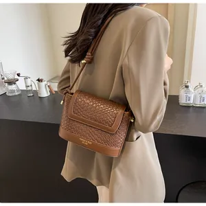Gros plan d'un sac marron texturé avec tissage détaillé et logo imprimé élégant