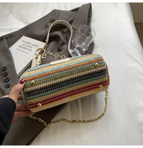 Macro detail of rainbow woven bucket bag showing gold base studs and metal chain strap