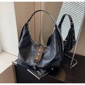 Detail view of black textured hobo bag with silver star rivets and metal hook detail