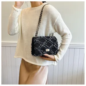 Détail du sac à rabat matelassé en tweed avec fermoir doré et bandoulière chaîne sur modèle
