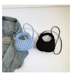Détail de sacs à plis nuages bleus et noirs avec texture matelassée et fines bandoulières